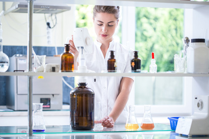 mujer química provando una nueva solución química en un laboratorio
